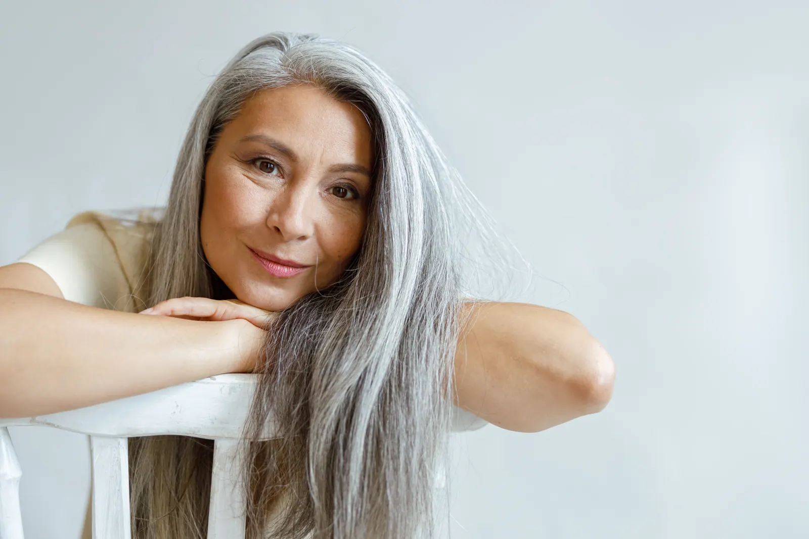 Attractive woman resting head on hands on chair