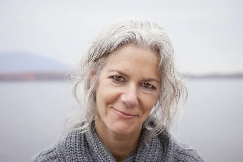 Calm woman with gray hair smiling outdoors
