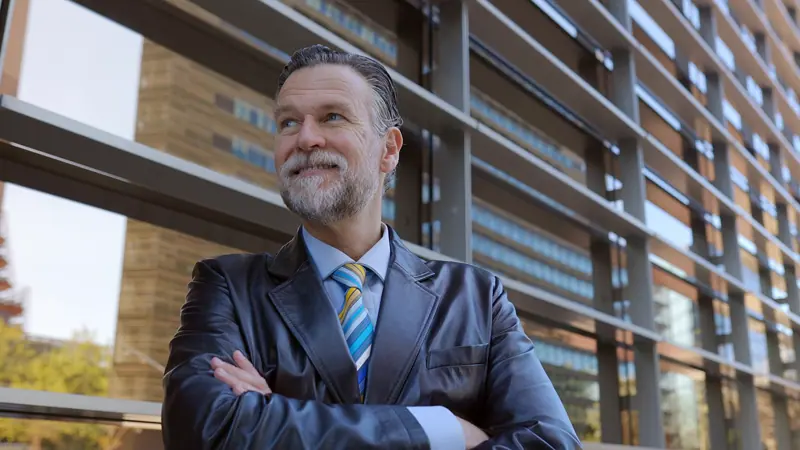Confident senior businessman smiling outside moder