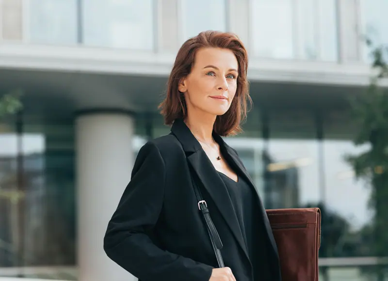Confident woman in blazer with shoulder bag outdoo