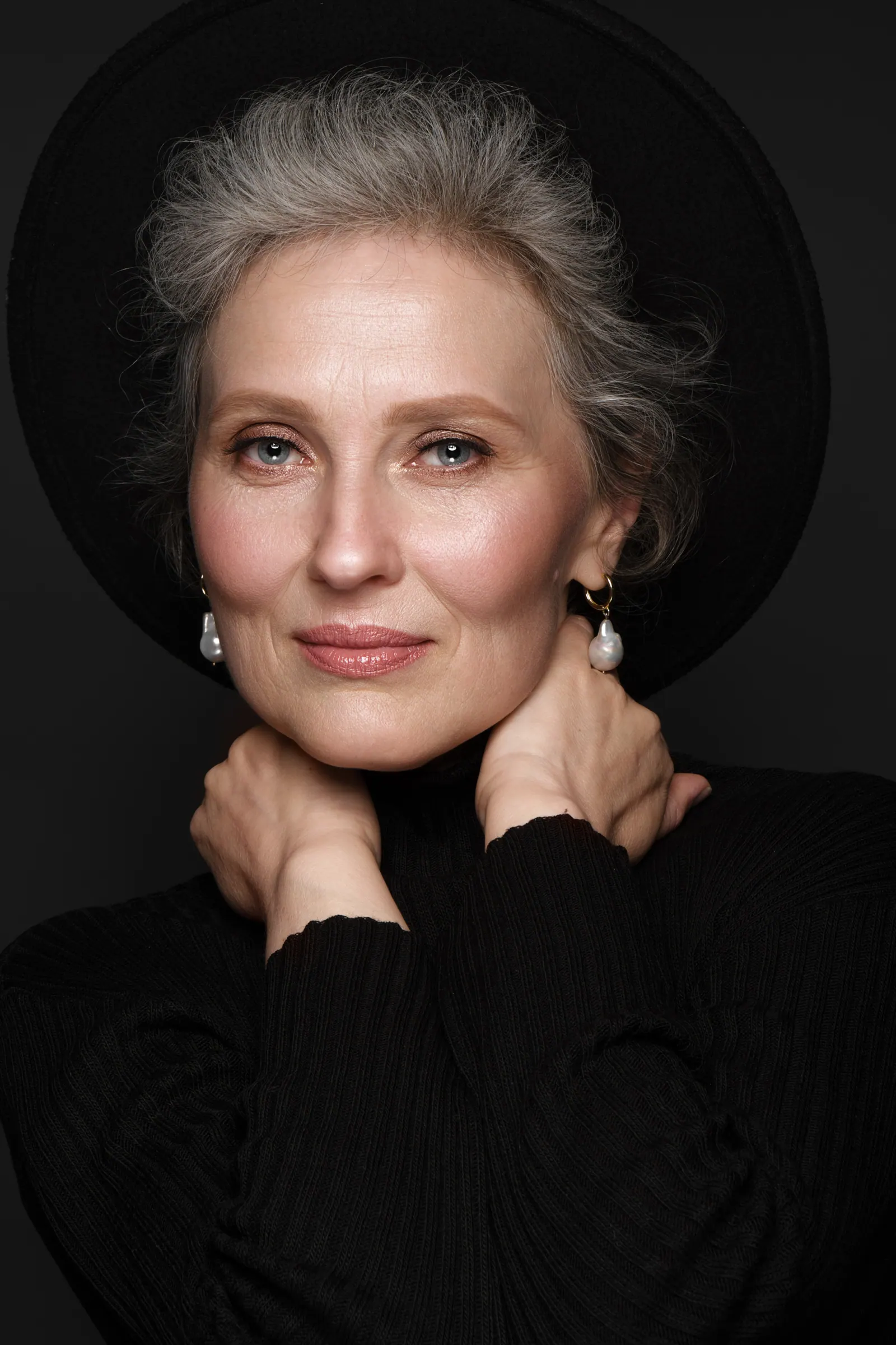 Elegant woman posing with black hat and earrings