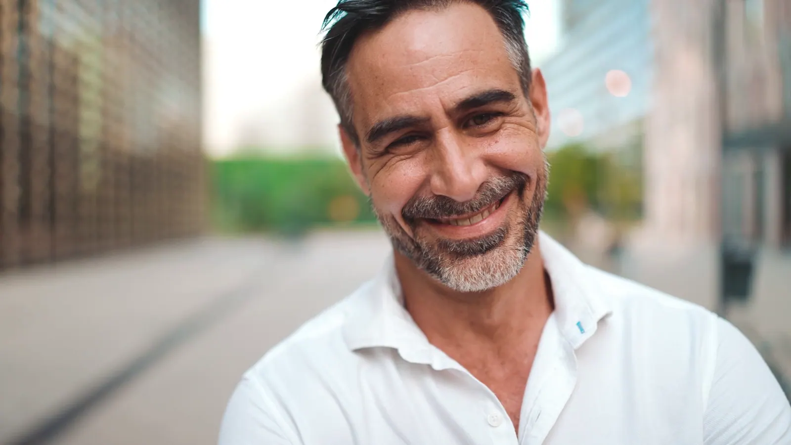 Mature man smiling confidently on city street