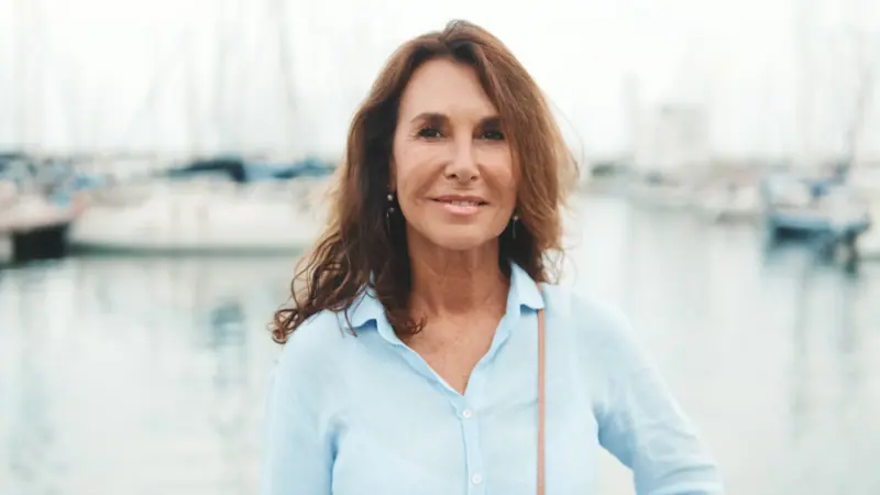 Relaxed woman by boats in a calm harbor
