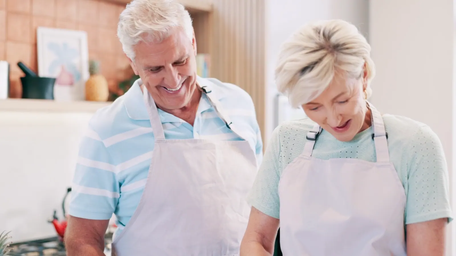 Senior couple laughing together in their kitchen