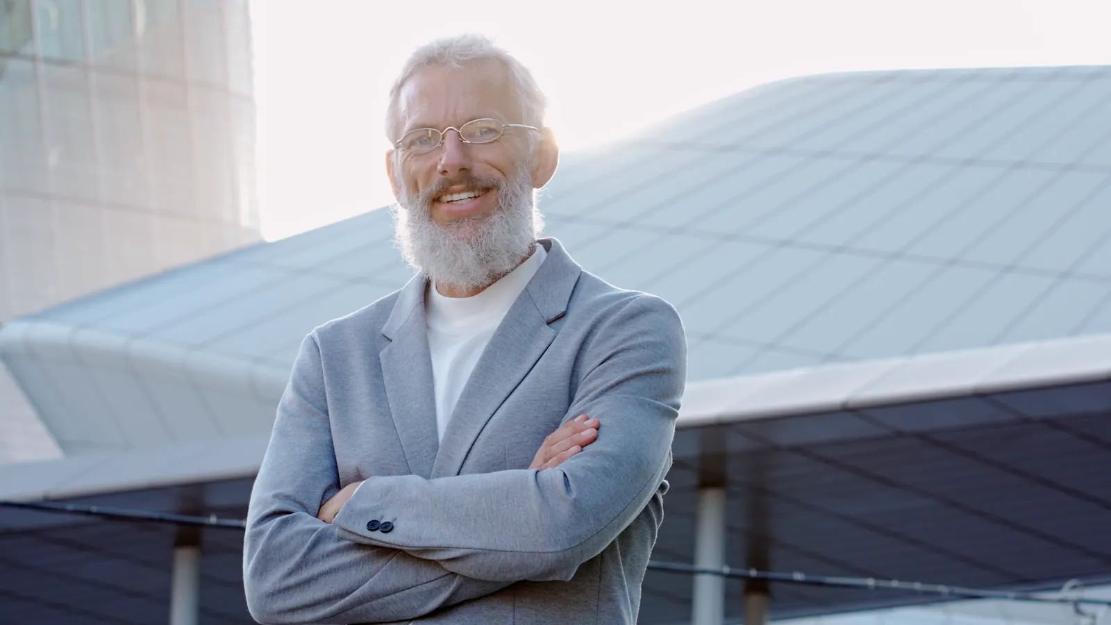 Senior man smiling confidently outside modern buil