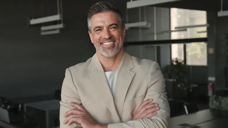 Smiling businessman standing in modern office
