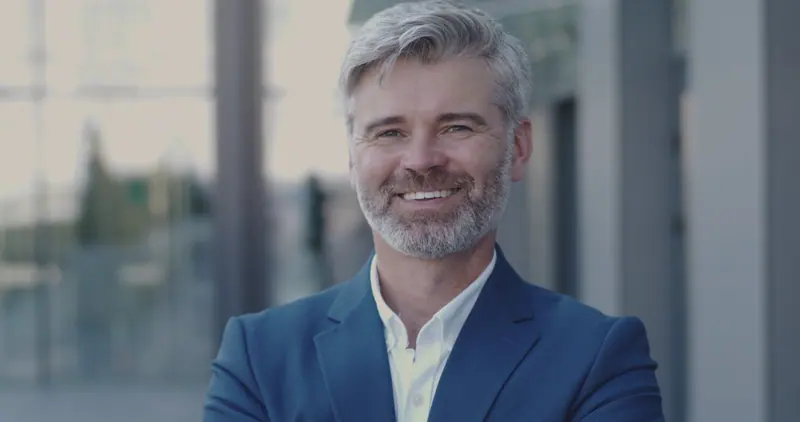 Smiling businessman with gray hair in blue suit
