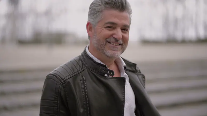 Smiling man with gray hair and leather jacket