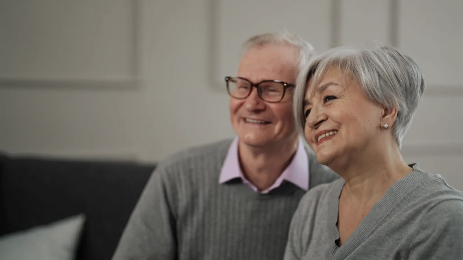 Smiling senior couple sitting together at home