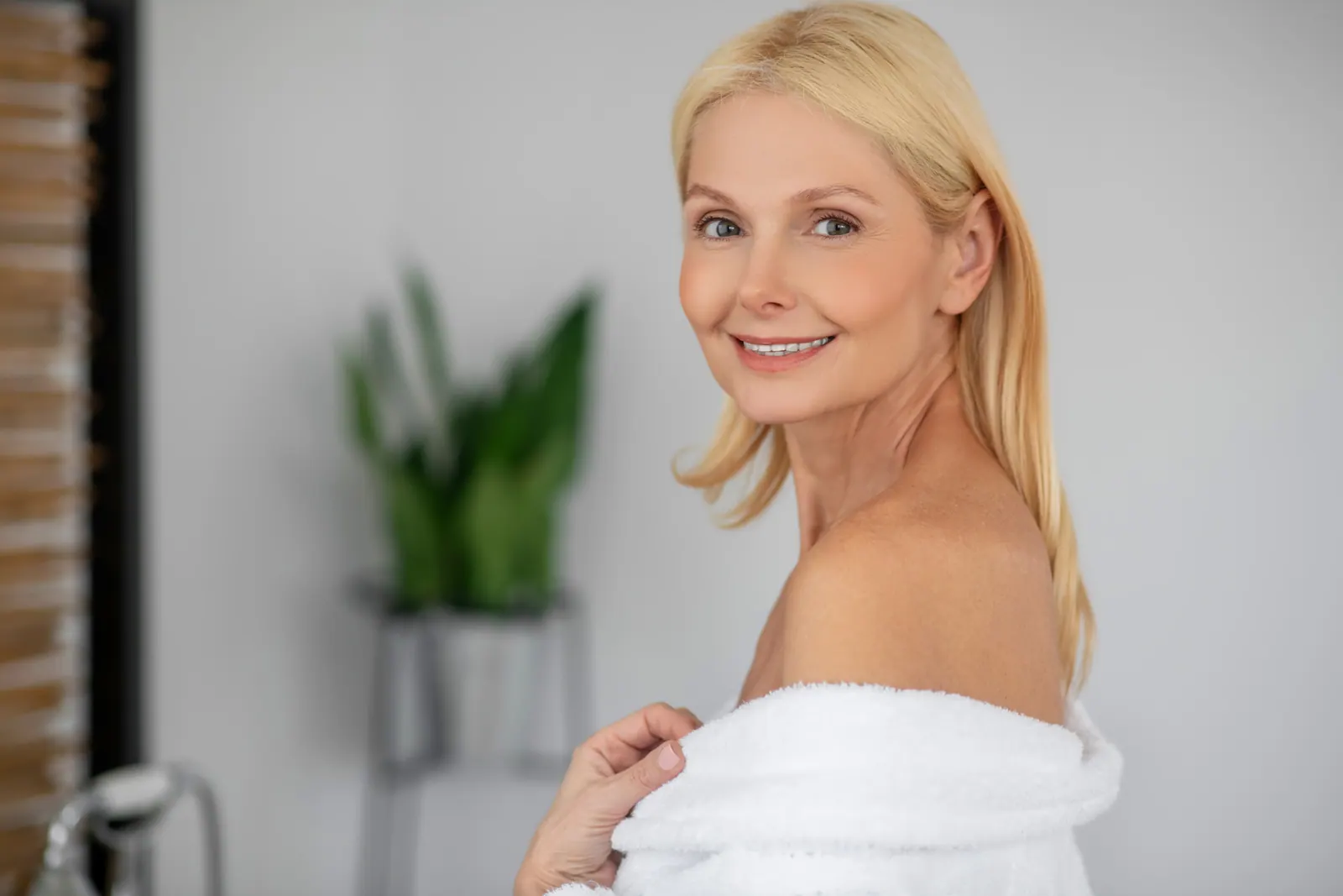 Smiling woman in white robe indoors