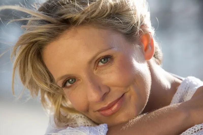 Smiling woman portrait with blonde hair and wind