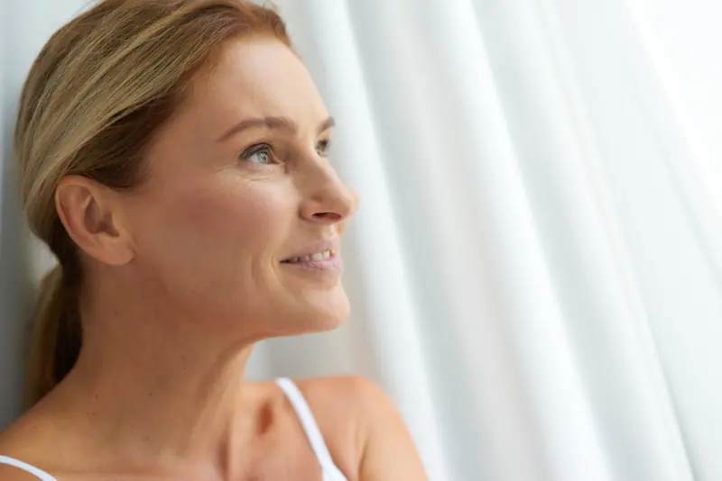 Smiling woman relaxing at home in soft light