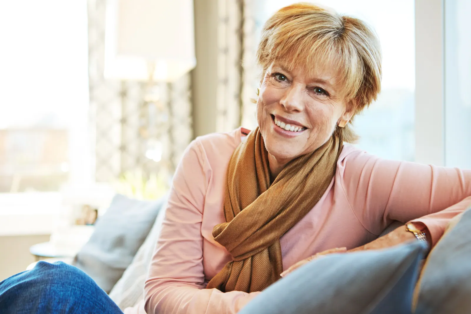 Smiling woman relaxing on sofa at home