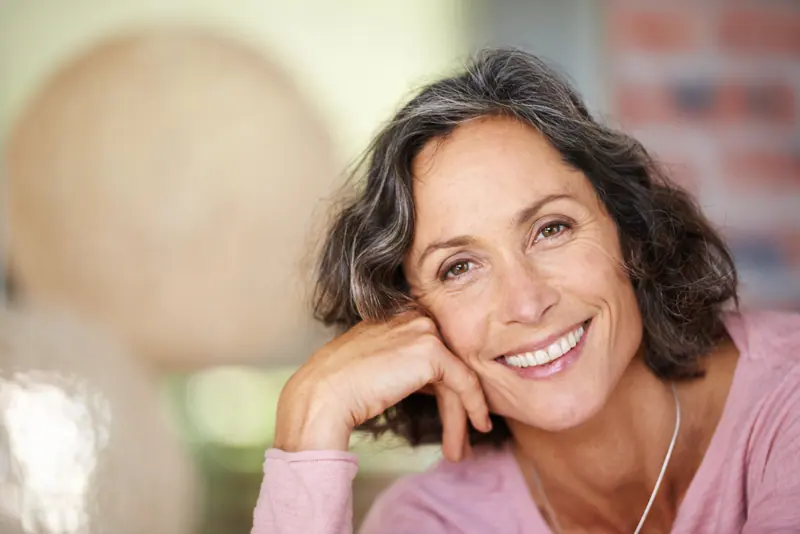 Smiling woman resting her head on her hand