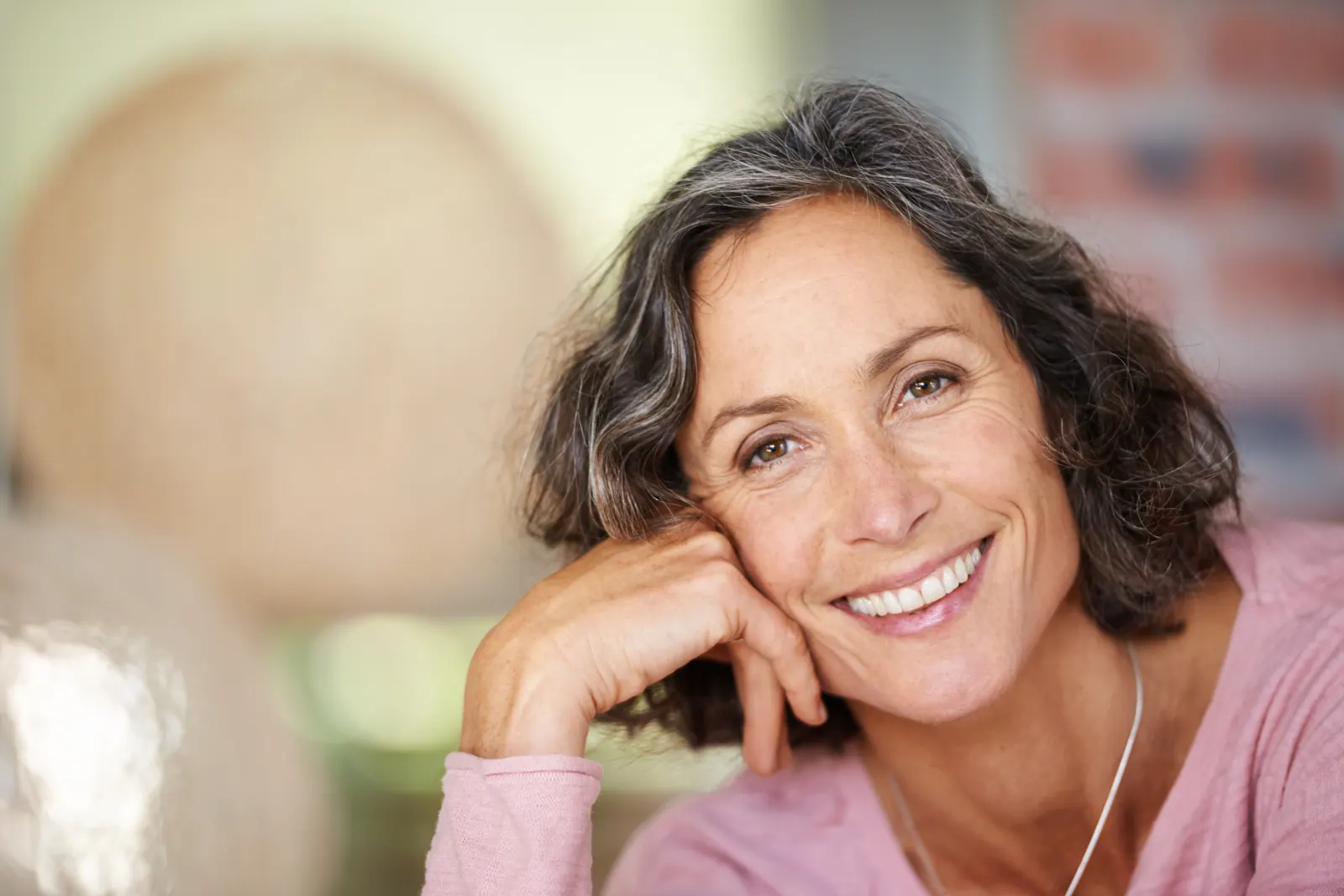 Smiling woman resting her head on her hand