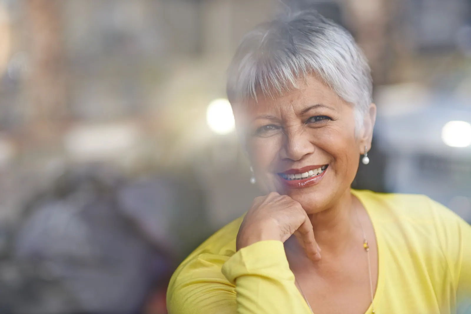 Smiling woman wearing yellow top in urban setting