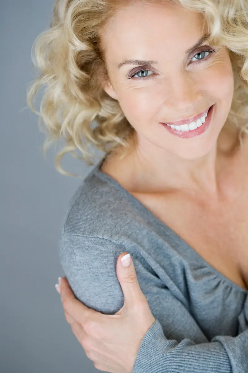 Smiling woman with blonde hair and gray shirt