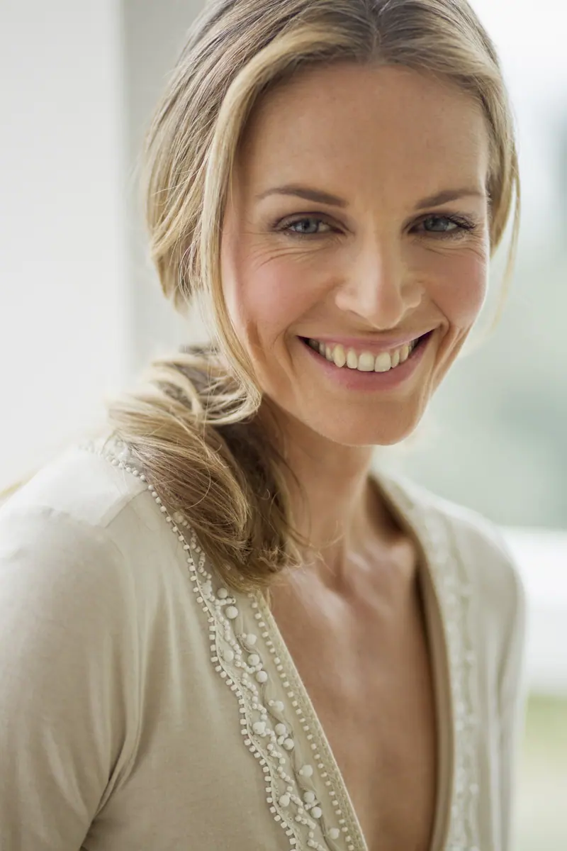 Smiling woman with blonde hair in natural light