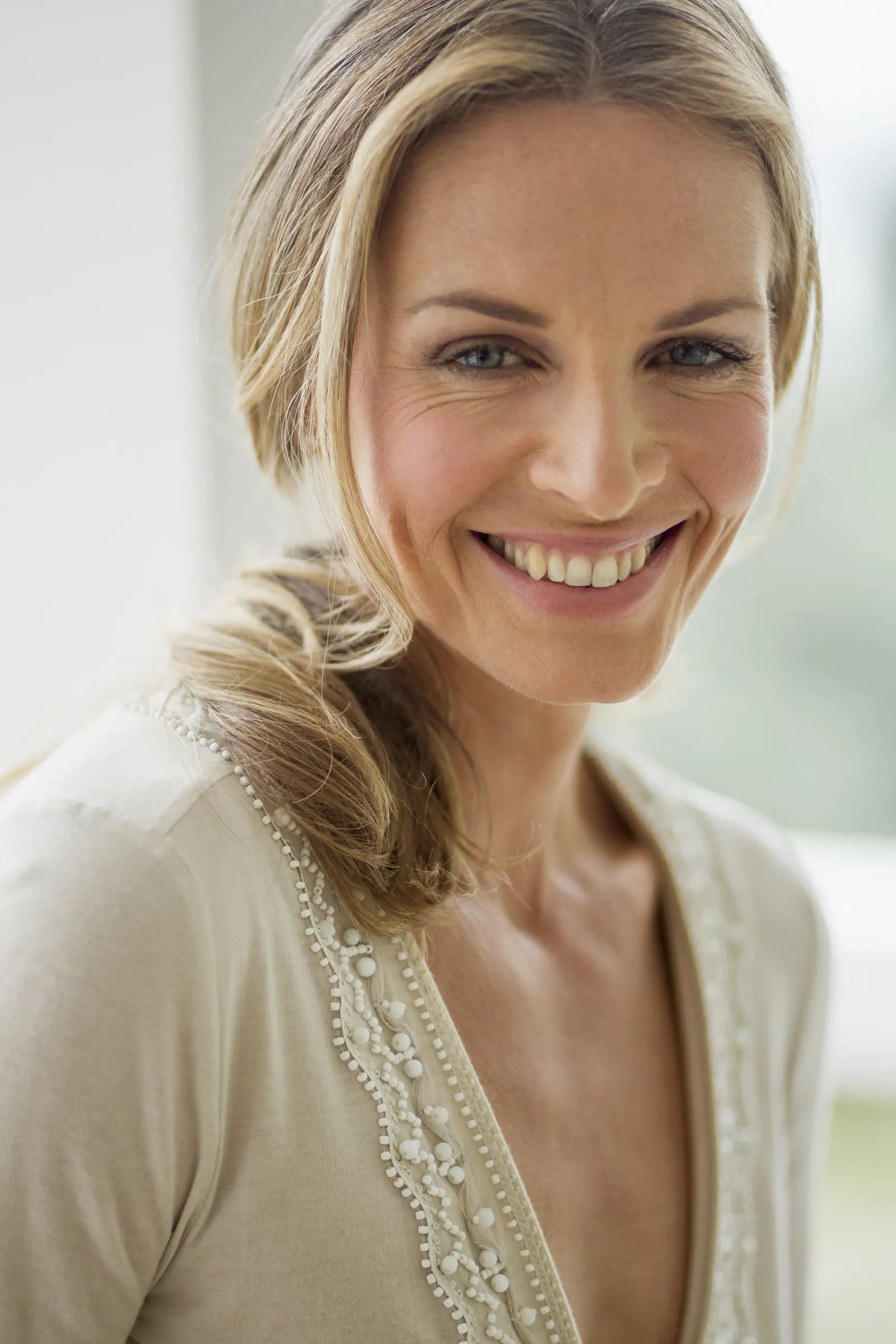 Smiling woman with blonde hair in natural light