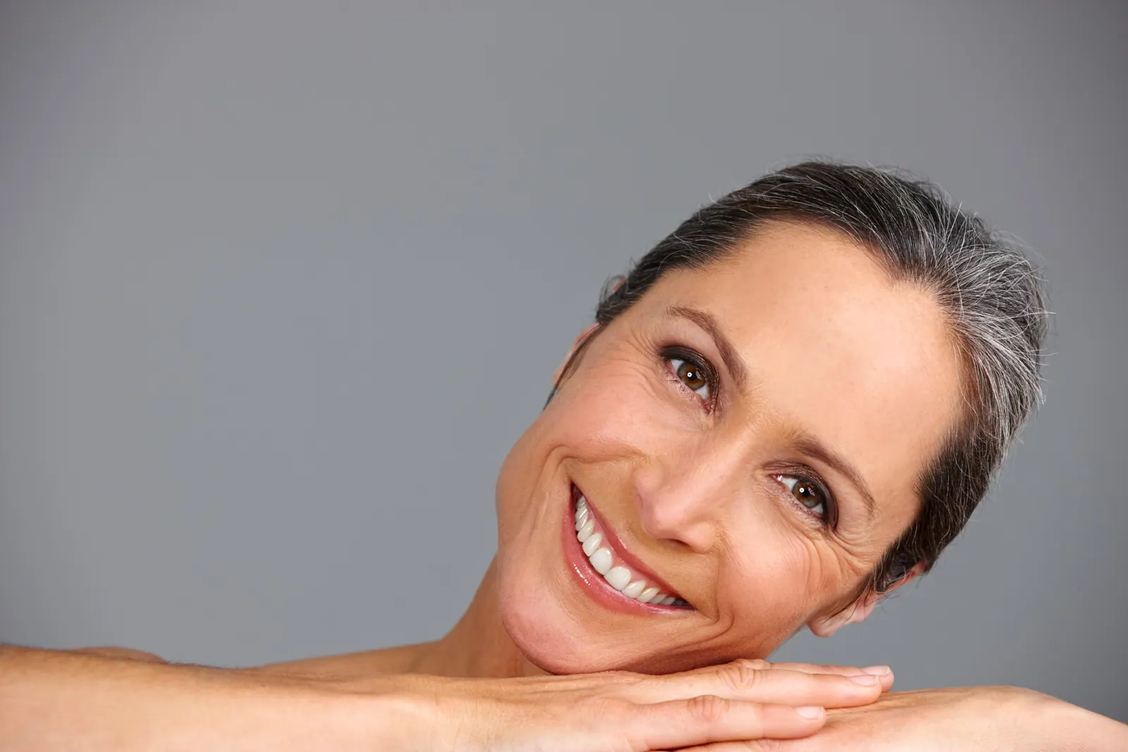 Smiling woman with gray hair leaning on hands
