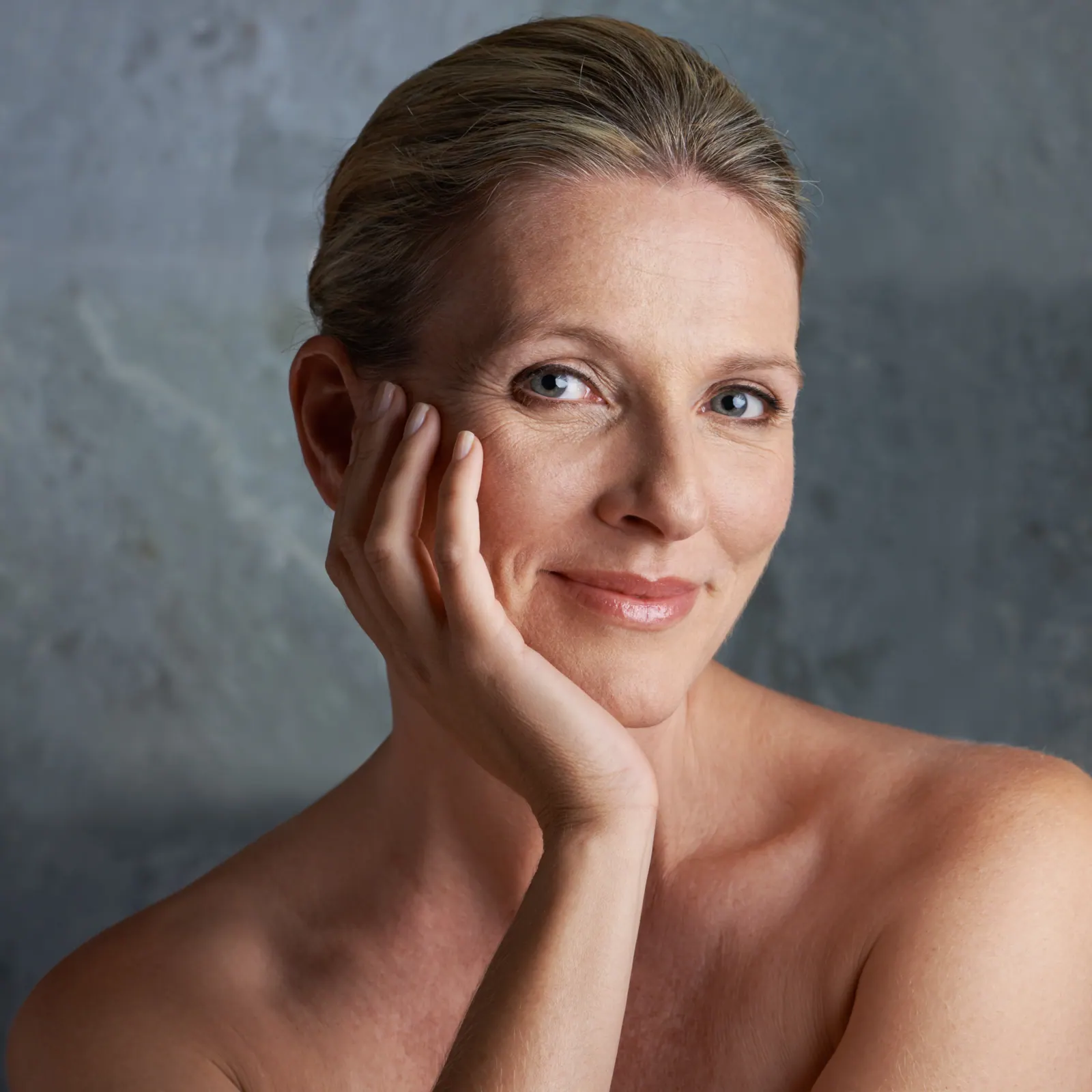 Smiling woman with hand to face posing