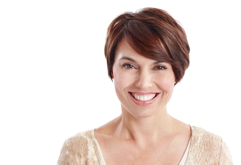Smiling woman with short brown hair posing against