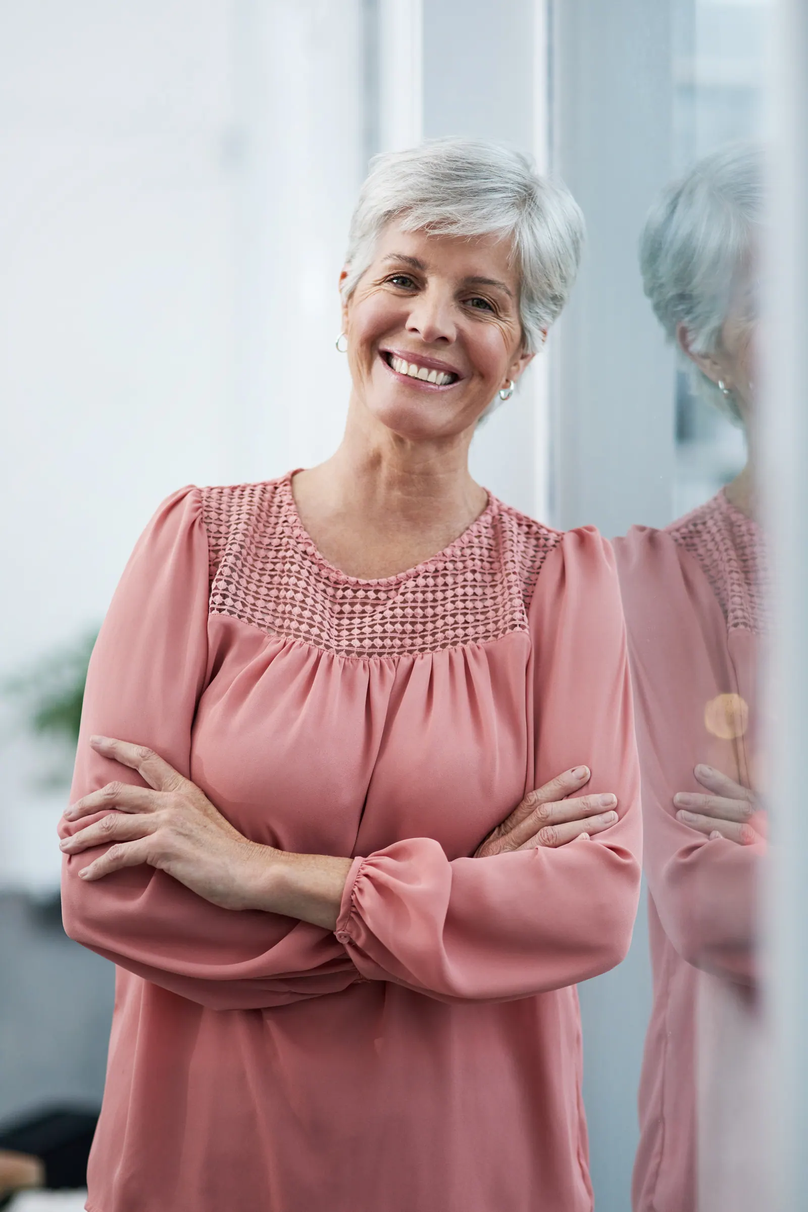 Smiling woman with short gray hair posing indoors