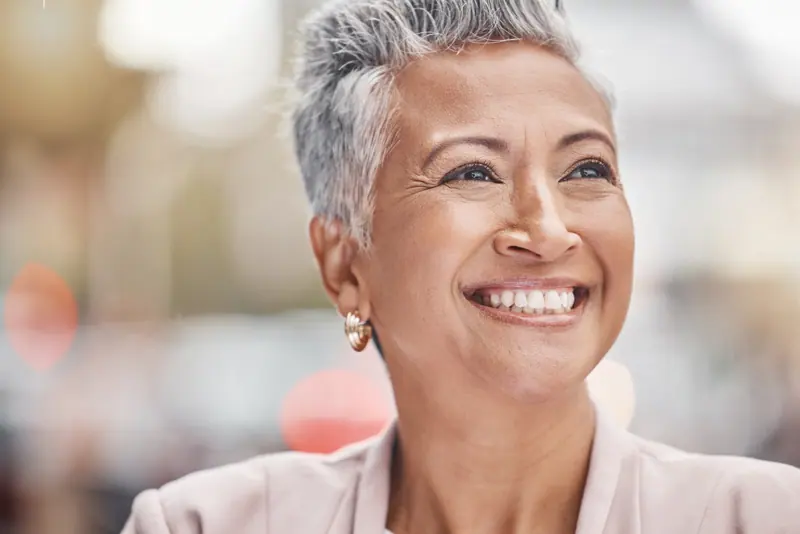 Smiling woman with short grey hair outdoors