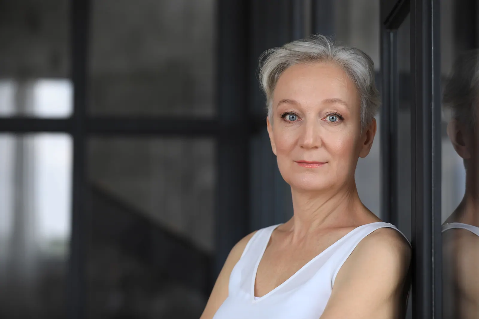 Thoughtful senior woman with short gray hair indoo