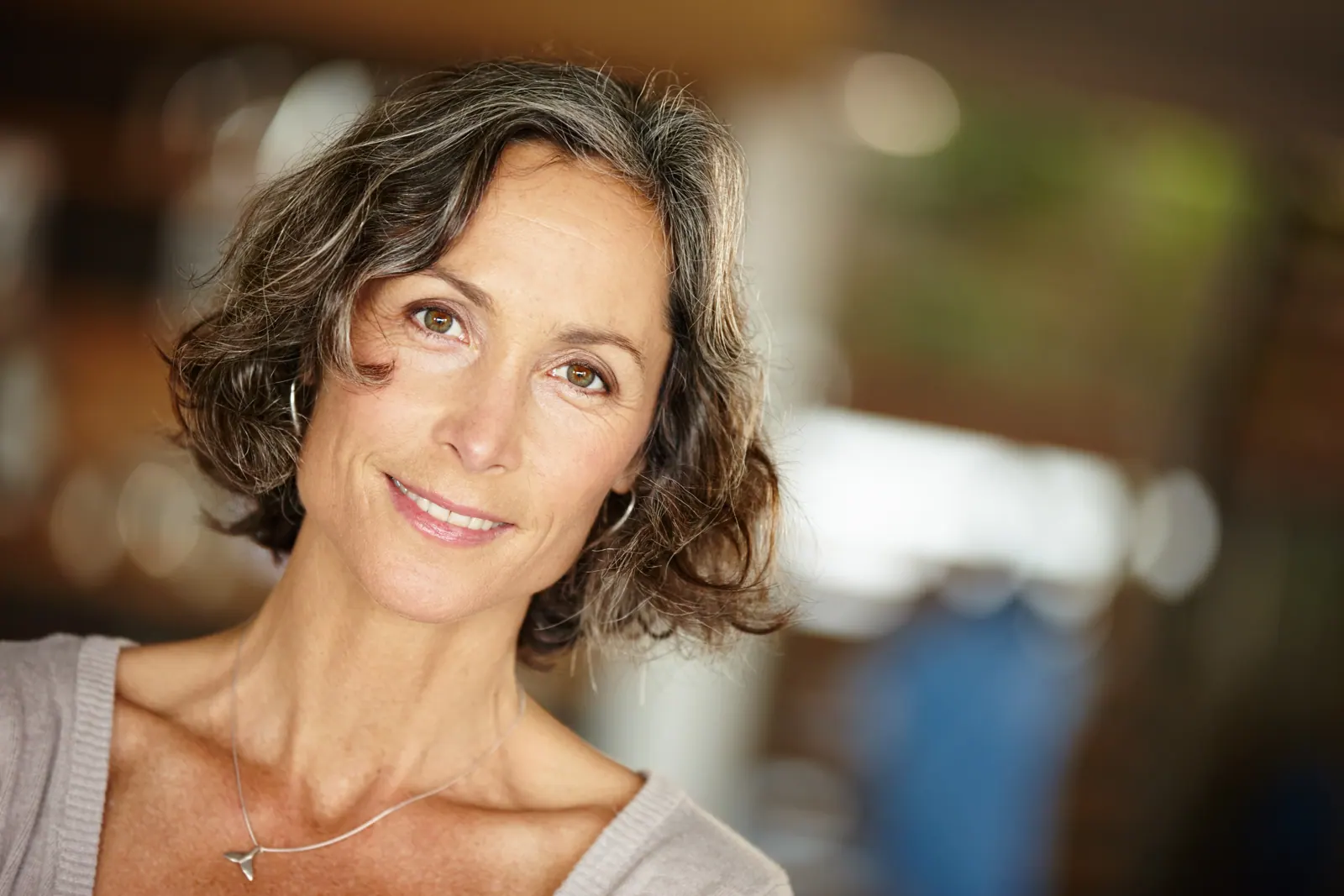 Woman smiling with short wavy hair indoors