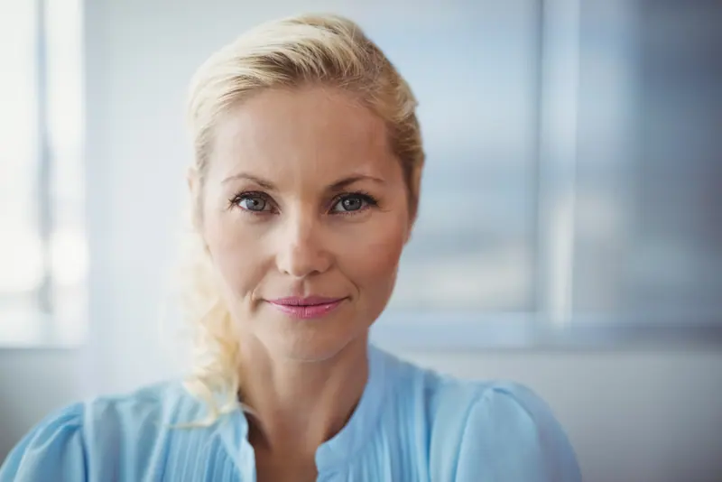 Woman with blond hair smiling in office setting