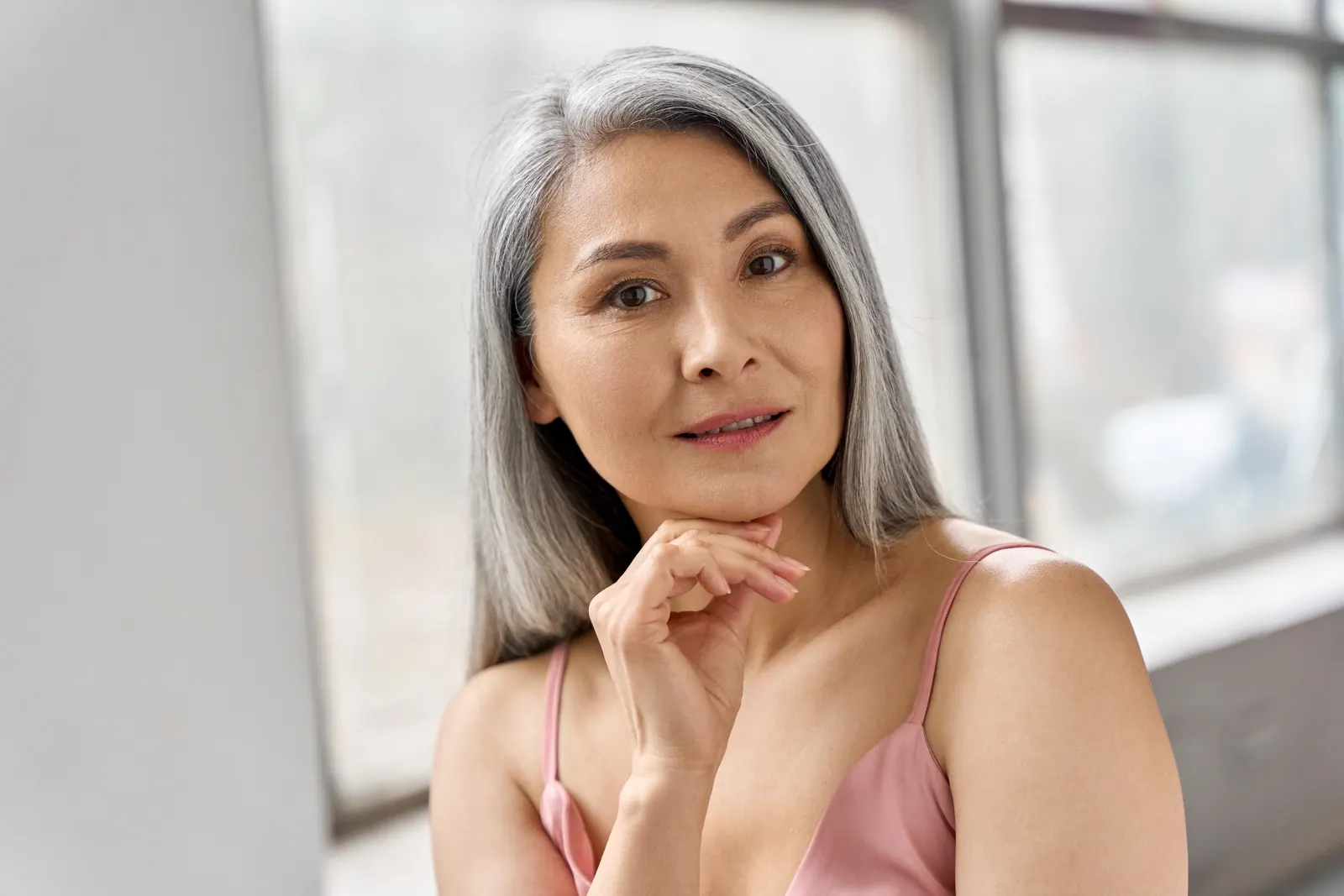 Woman with gray hair posing indoors